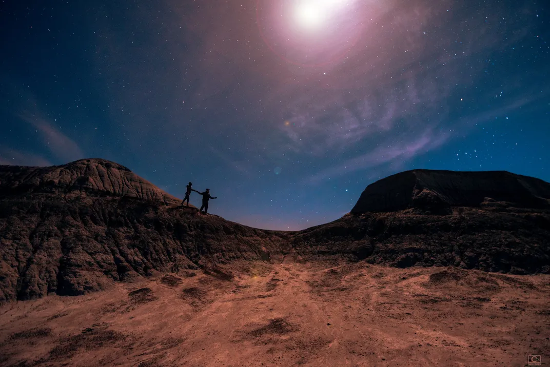 two people on the rocky terrain at night