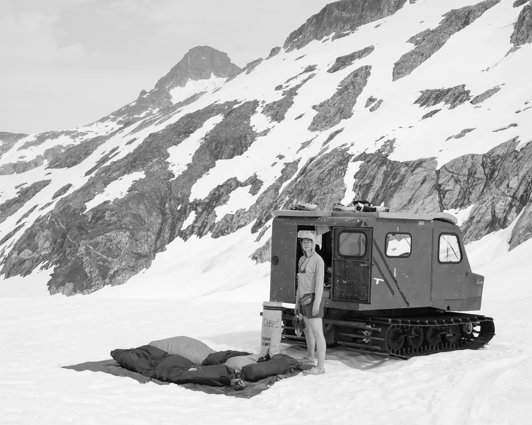 Dibble packs up her sleeping bag after spending the night on the roof of a Thiokol Snowcat. The camps have bunkhouses, but participants can opt to sleep outdoors.