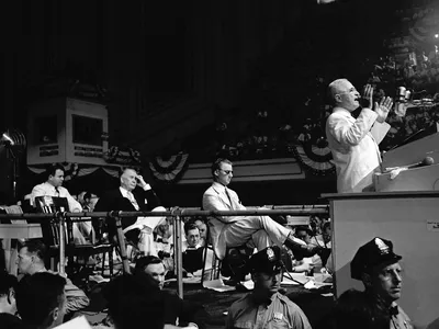 President Harry S. Truman speaks from the dais at the Convention Hall as Kentucky Senator Alben Barkley (seated onstage in black suit) looks on during the 1948 Democratic National Convention in Philadelphia.