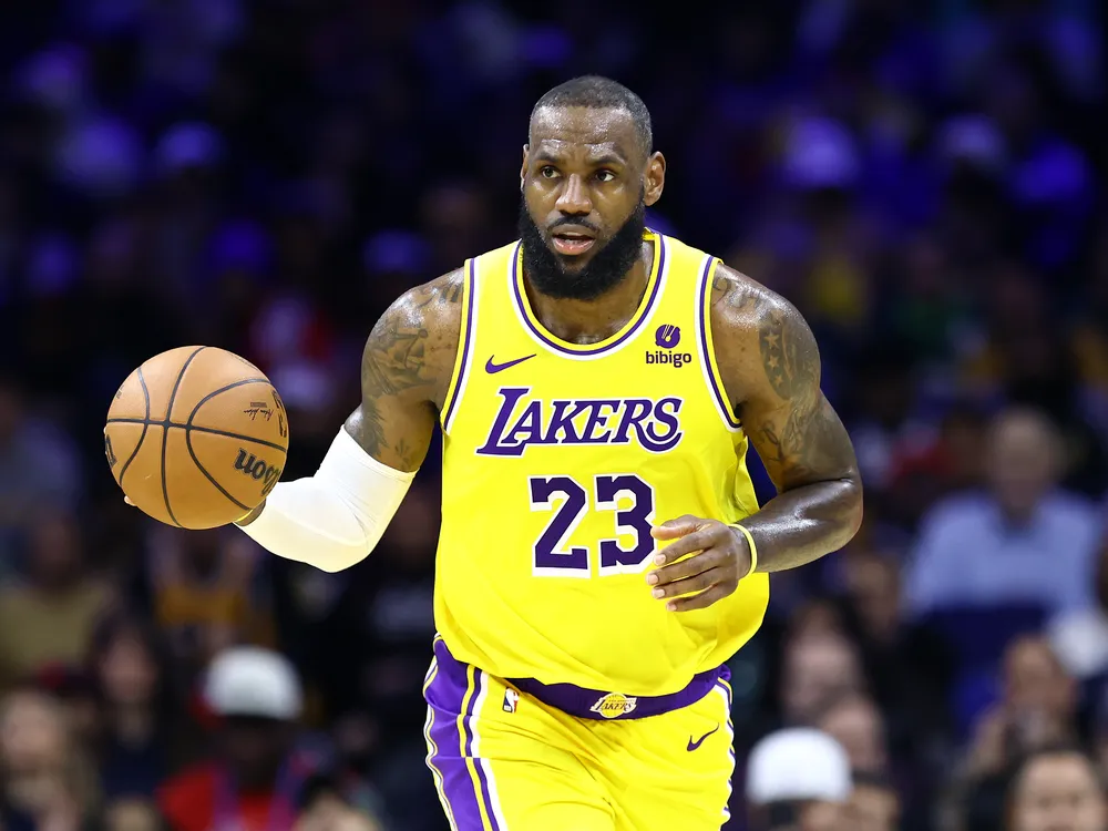 LeBron James dribbling a basketball in a yellow Lakers jersey