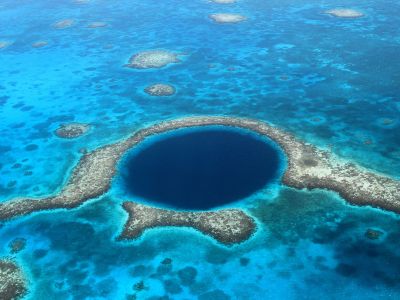 Blue holes, like the Great Blue Hole in Belize, are vast caverns that descend into the seafloor. Sediment accumulates at the bottom of a blue hole, giving researchers a way to gauge historical hurricane activity.
