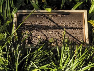 Sunlight illuminates a plaque in Charleston, South Carolina, honoring 36 likely enslaved people&mdash;ranging in age from 3 to over 50&mdash;whose remains were discovered in 2013.