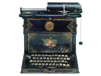 Sholes and Glidden gussied up an early model with floral ornaments, in imitation of sewing machines.